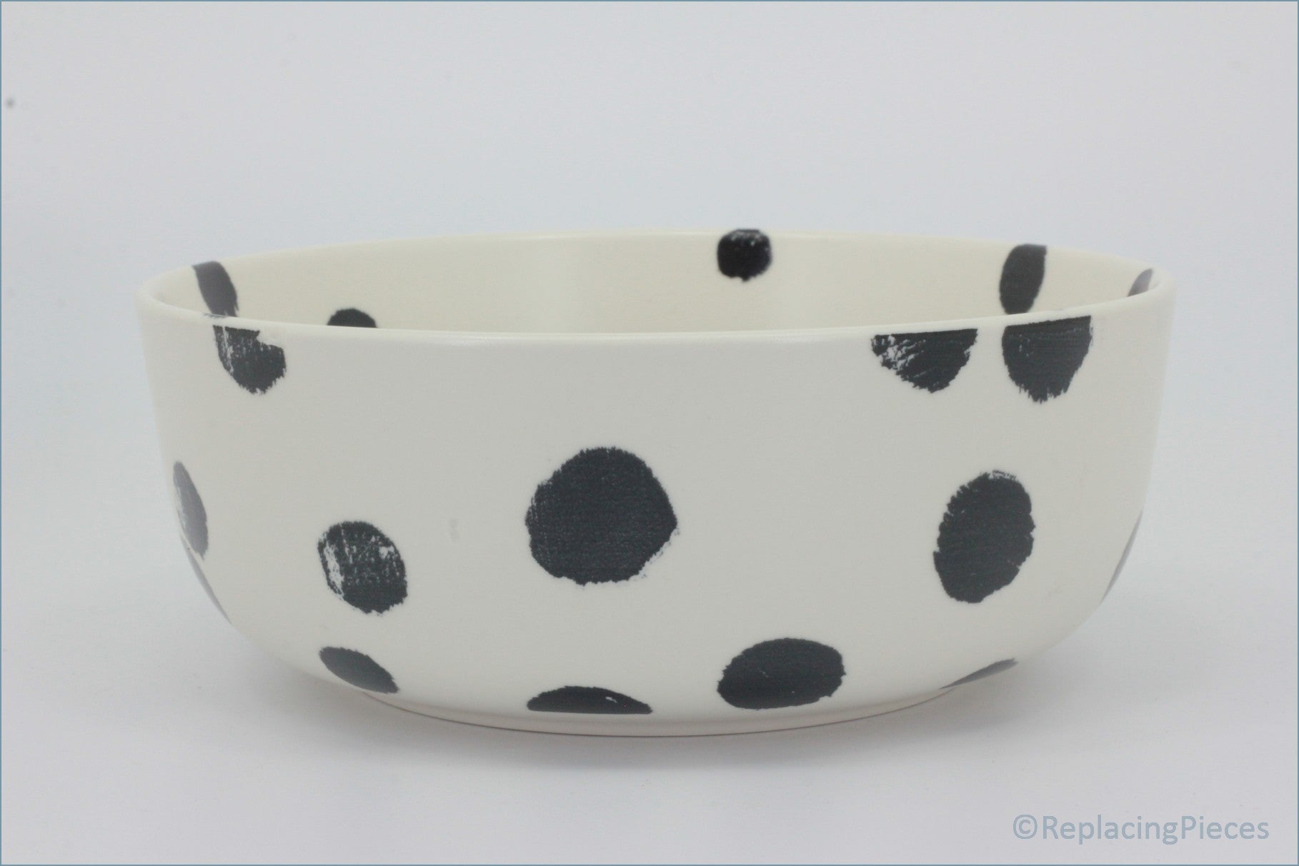 Habitat - Global - Cereal Bowl - White ceramic bowl with black polka dots on a white background